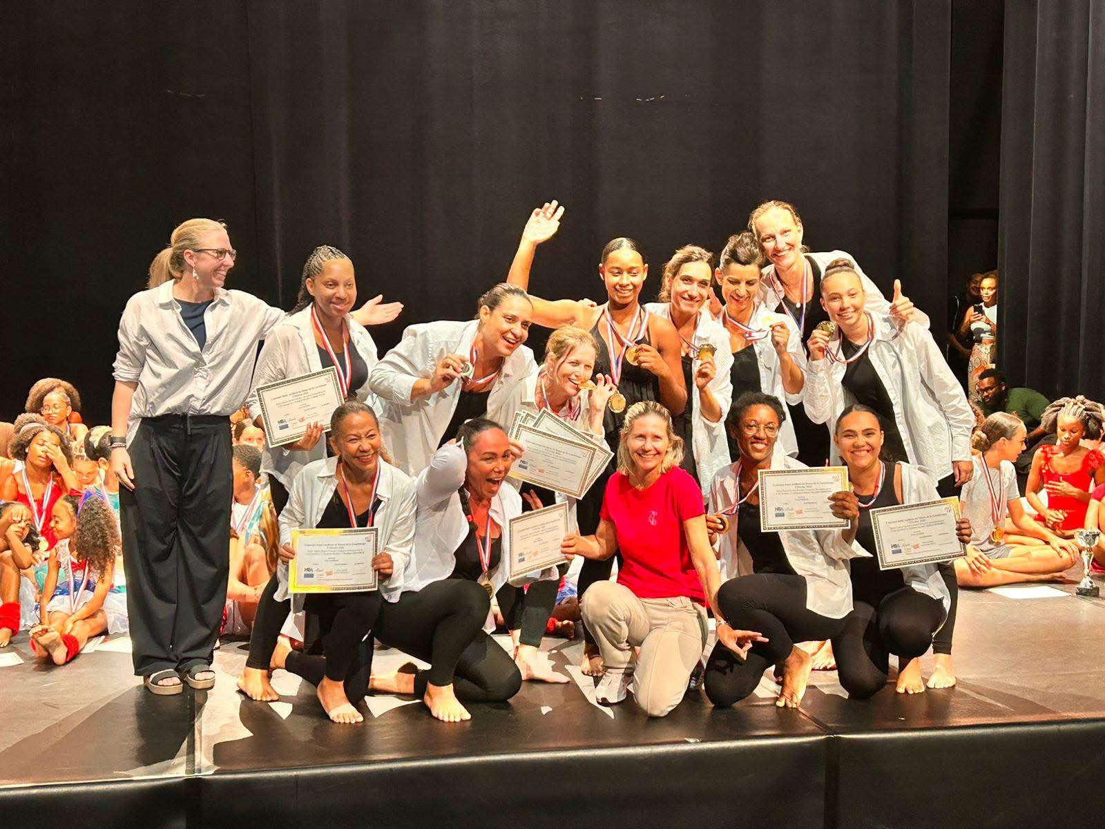 Groupe Adulte Femmes Debouts sur scène avec leurs diplômes, 1er prix au Concours Inter-Caribéen